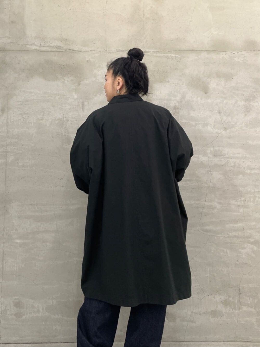 ホワイト系のトートバッグ、ブルー系のデニムパンツ、ブラック系のその他アウターを着用したレディースの冬コーディネートの7枚目の写真