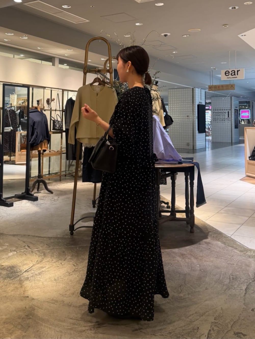 ブラック系のハンドバッグ、ブラック系のワンピースを着用したレディースの春コーディネートの5枚目の写真