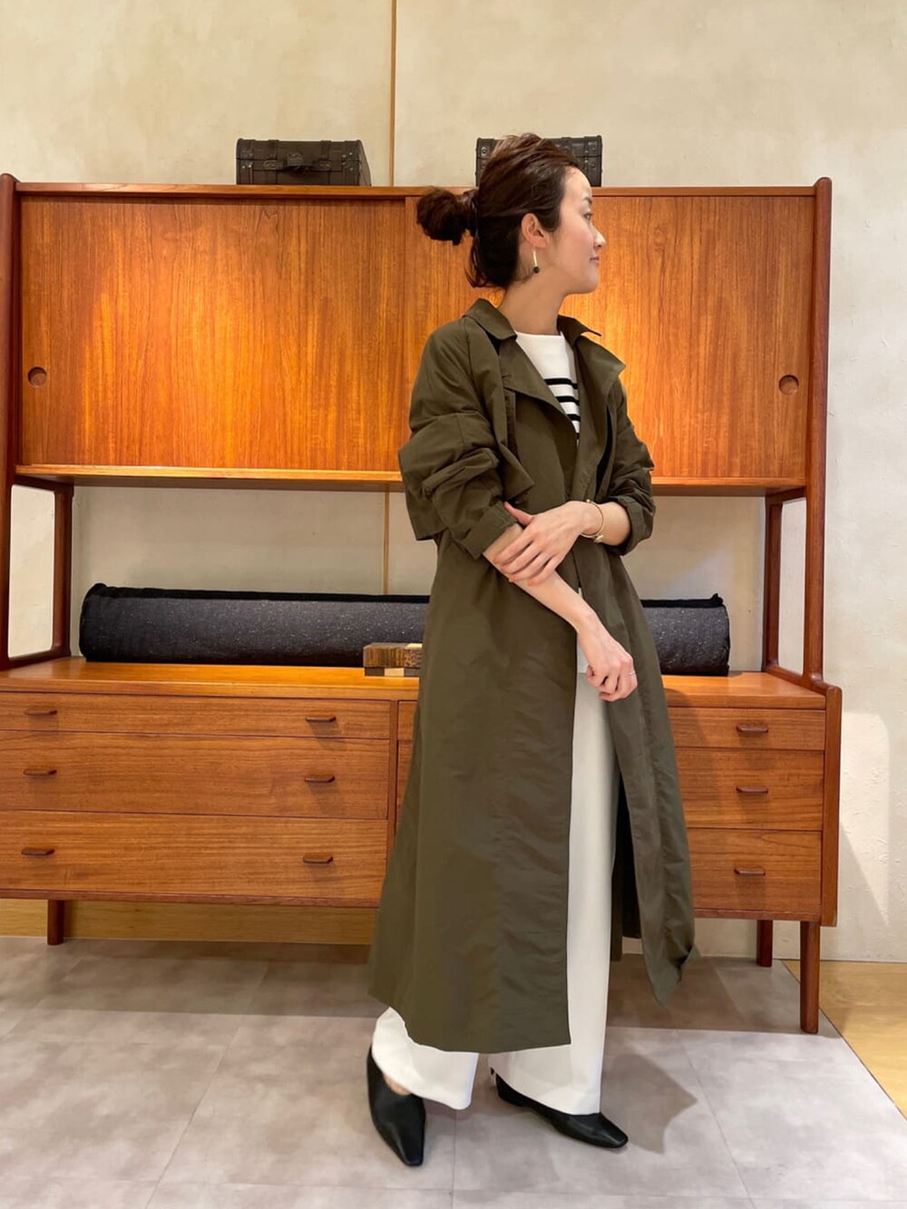 ベージュ系のその他アウター、ブラック系のニット/セーター、グリーン系のトートバッグを着用したレディースの春コーディネートの3枚目の写真