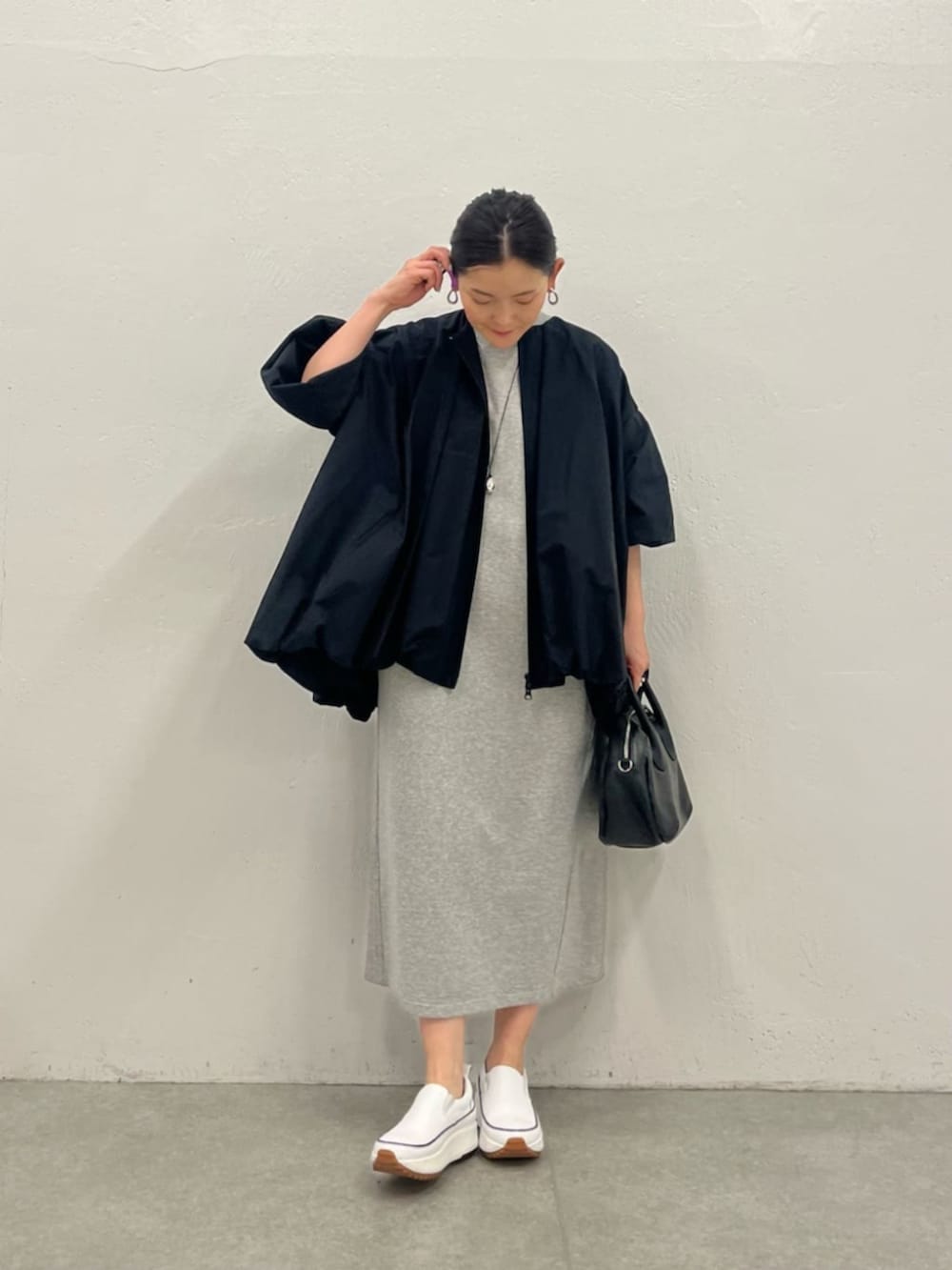 ブラック系のブルゾン、グレー系のワンピースを着用したレディースの冬コーディネートの5枚目の写真