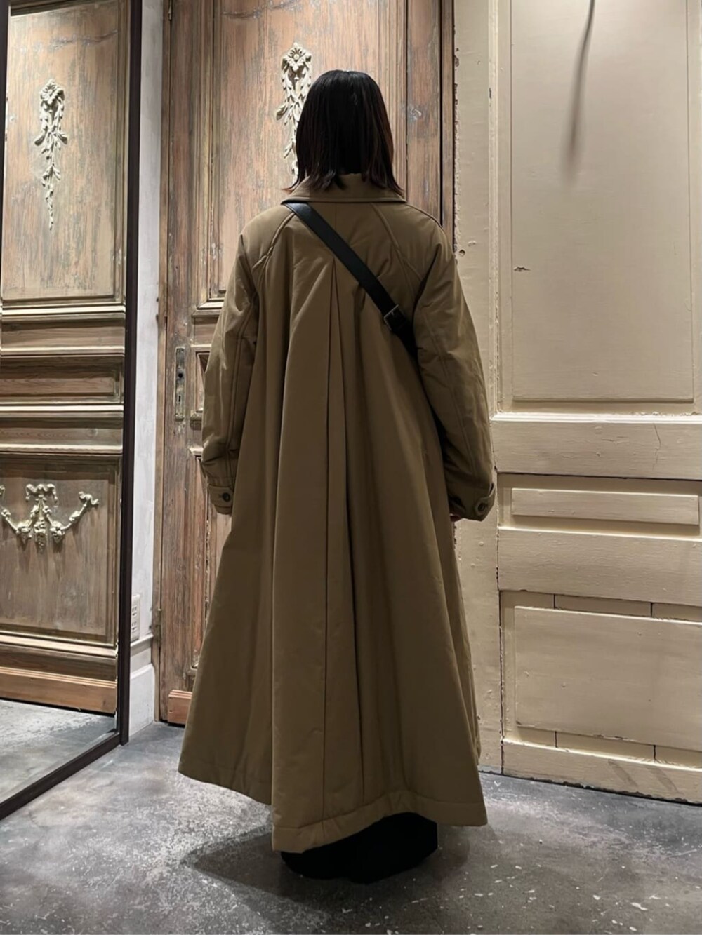 ブラック系のショルダーバッグ、イエロー系のその他アウター、ブラック系のチャームを着用したレディースの冬コーディネートの4枚目の写真