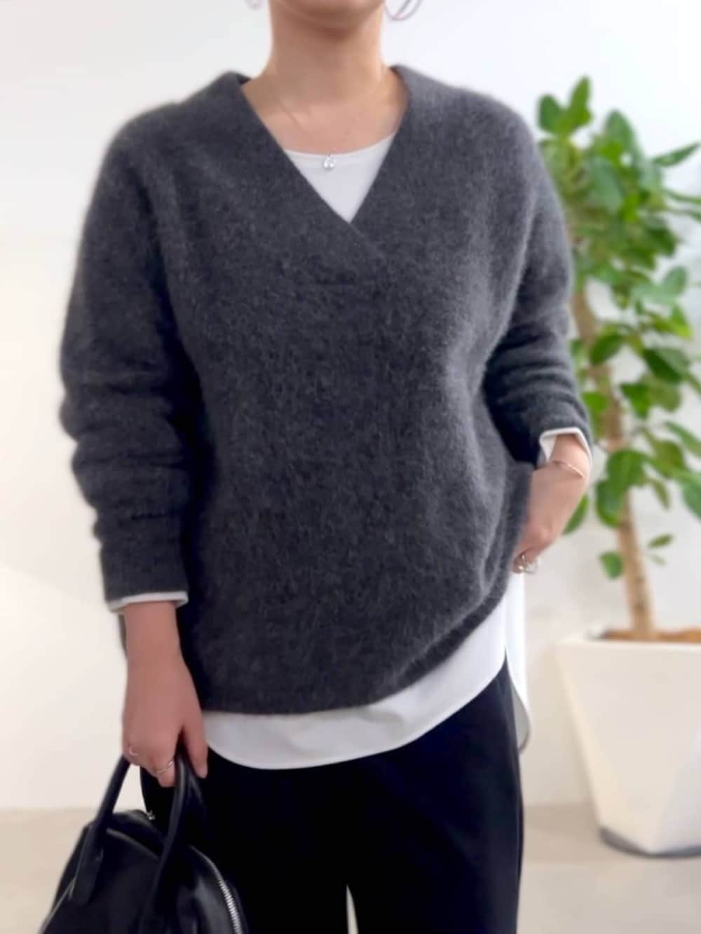 ブラック系のトートバッグ、グレー系のニット/セーター、ホワイト系のシャツ/ブラウスを着用したレディースの秋コーディネートの5枚目の写真