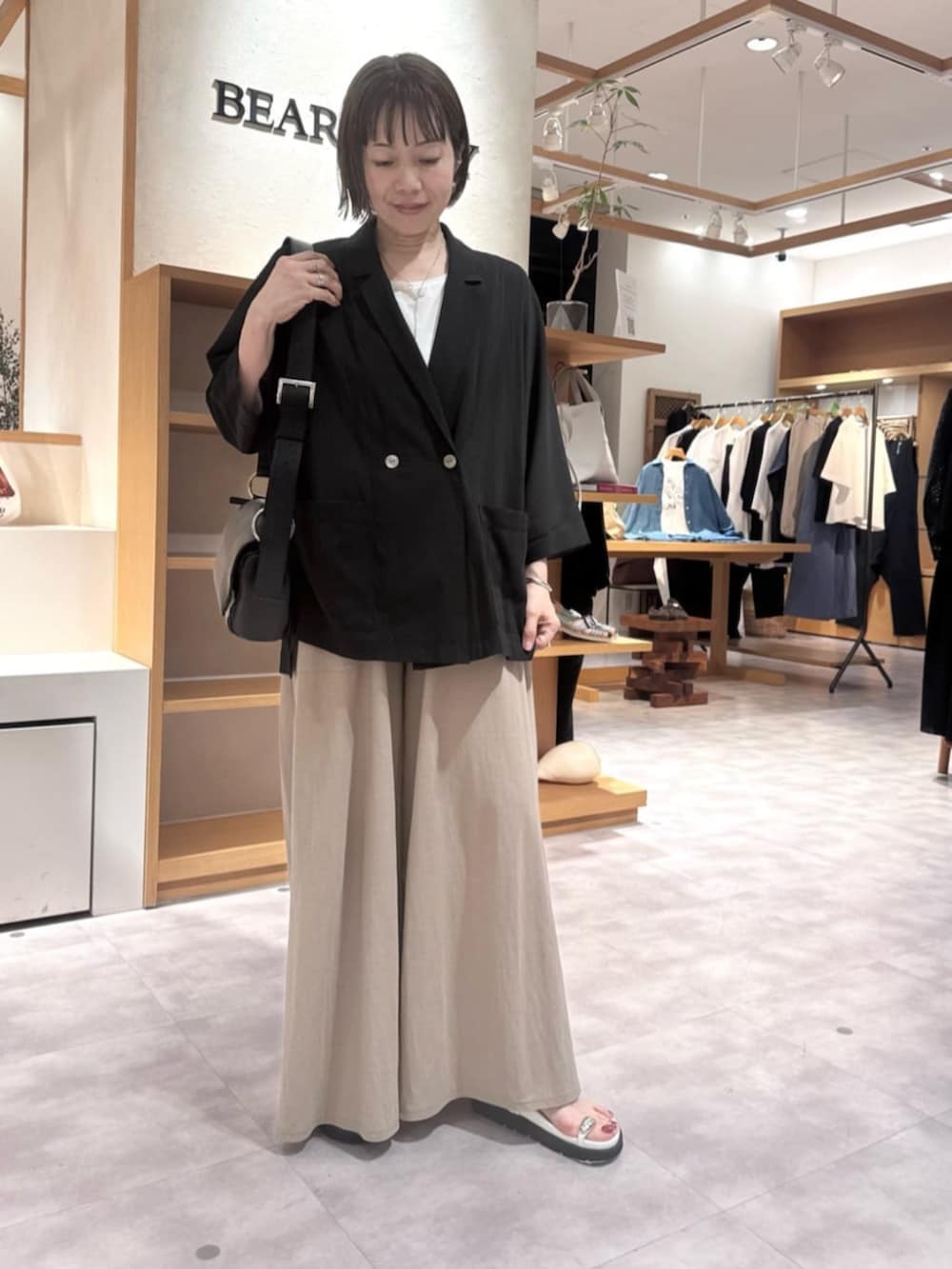 ブラック系のテーラードジャケット、ベージュ系のその他パンツ、ホワイト系のサンダルを着用したレディースの春コーディネートの7枚目の写真
