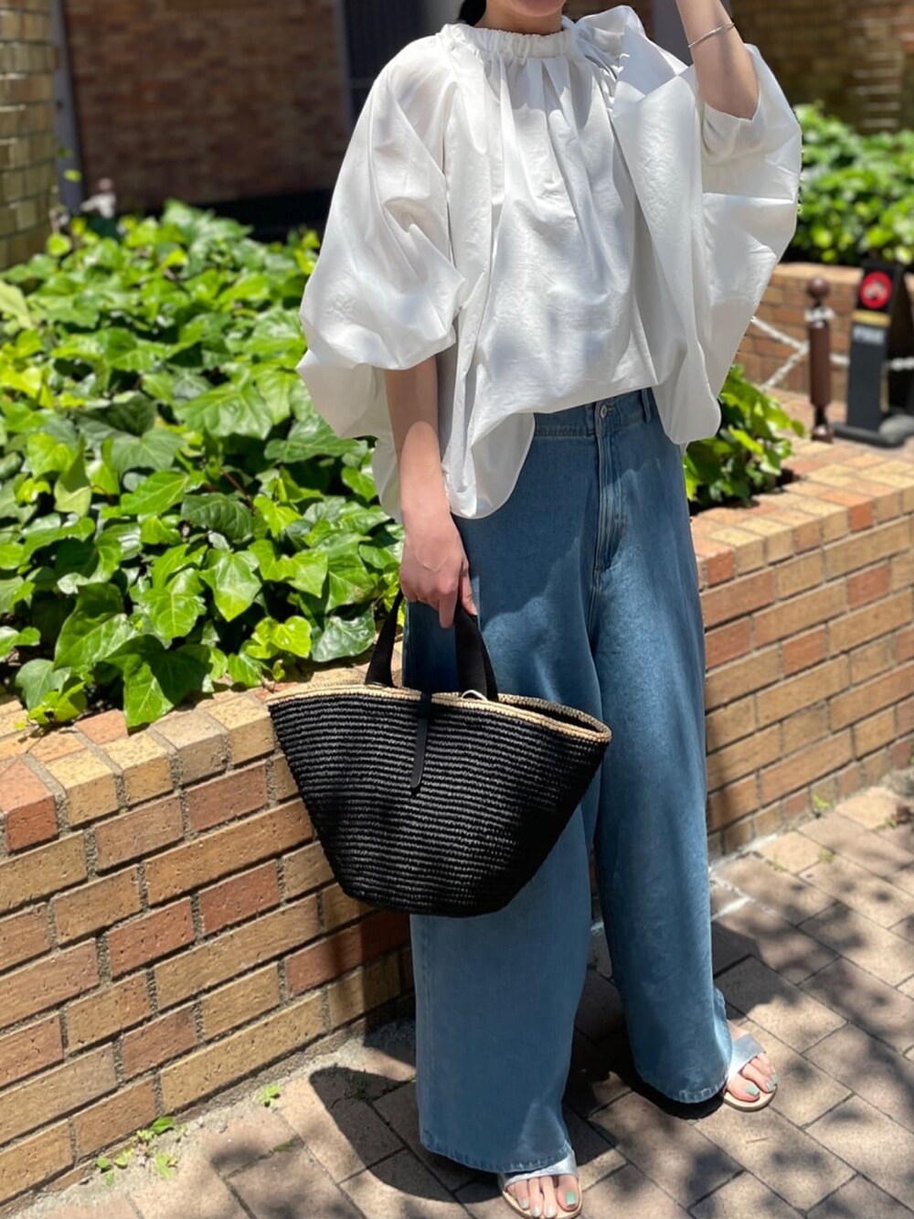 ホワイト系のシャツ/ブラウス、ブルー系のデニムパンツ、ブラック系のかごバッグを着用したレディースの春コーディネートの2枚目の写真