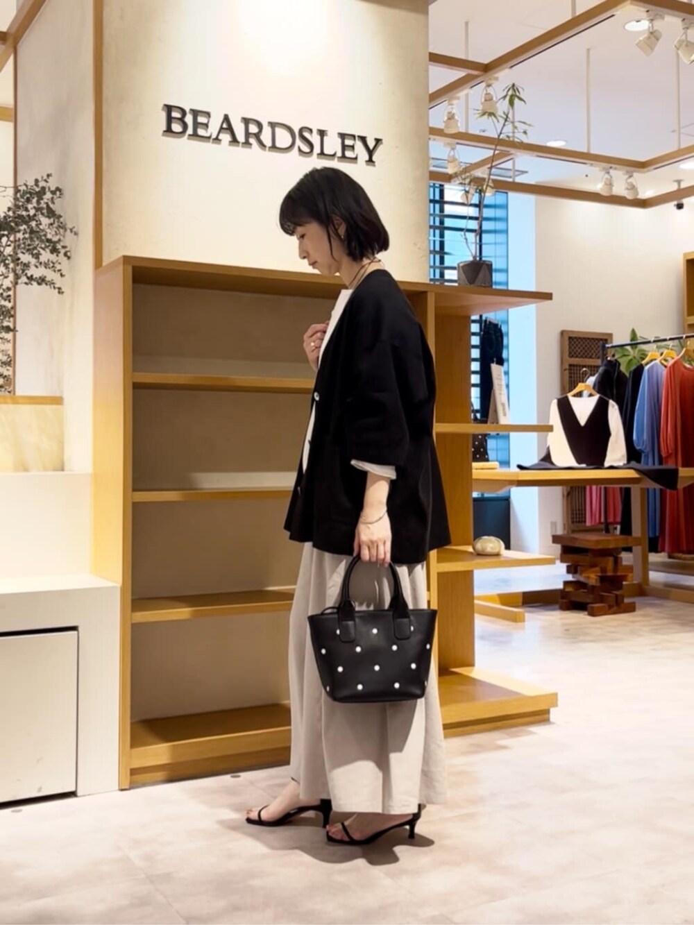 ブラック系のトートバッグ、ホワイト系のシャツ/ブラウス、グレー系のその他パンツを着用したレディースの春コーディネートの3枚目の写真