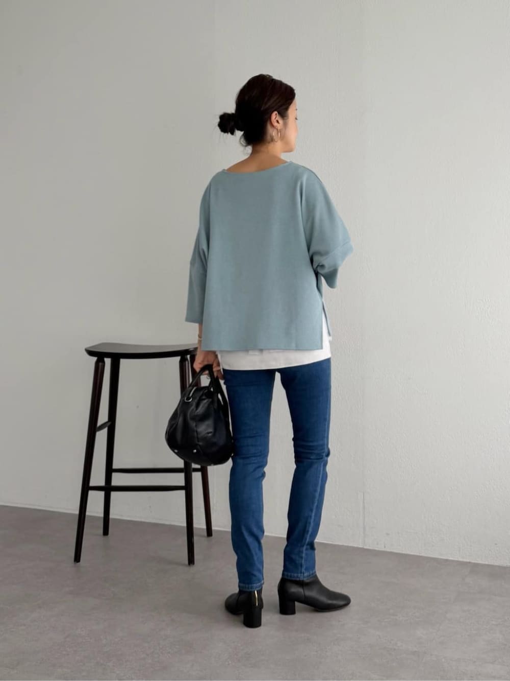 ブルー系のデニムパンツ、ブルー系のニット/セーター、ホワイト系のキャミソールを着用したレディースの夏コーディネートの6枚目の写真