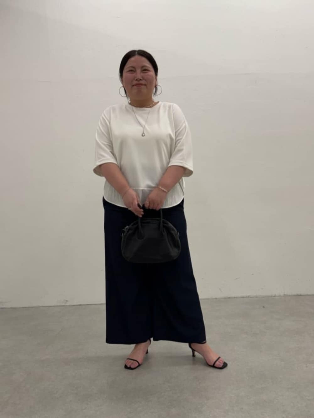 ブラック系のボストンバッグ、ブルー系のその他パンツ、ホワイト系のTシャツ/カットソーを着用したレディースの春コーディネートの2枚目の写真