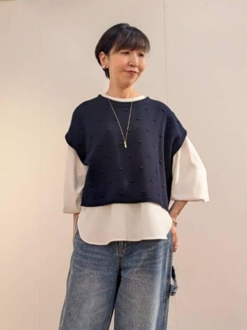 ブルー系のデニムパンツ、ホワイト系のシャツ/ブラウス、ブルー系のベストを着用したレディースの秋コーディネートの2枚目の写真