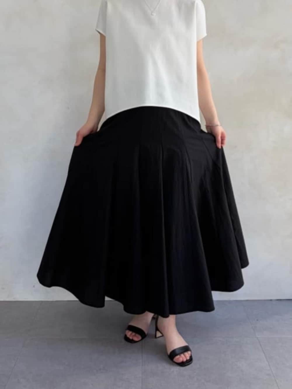 ブラック系のハンドバッグ、ホワイト系のシャツ/ブラウス、ブラック系のスカートを着用したレディースの春コーディネートの5枚目の写真