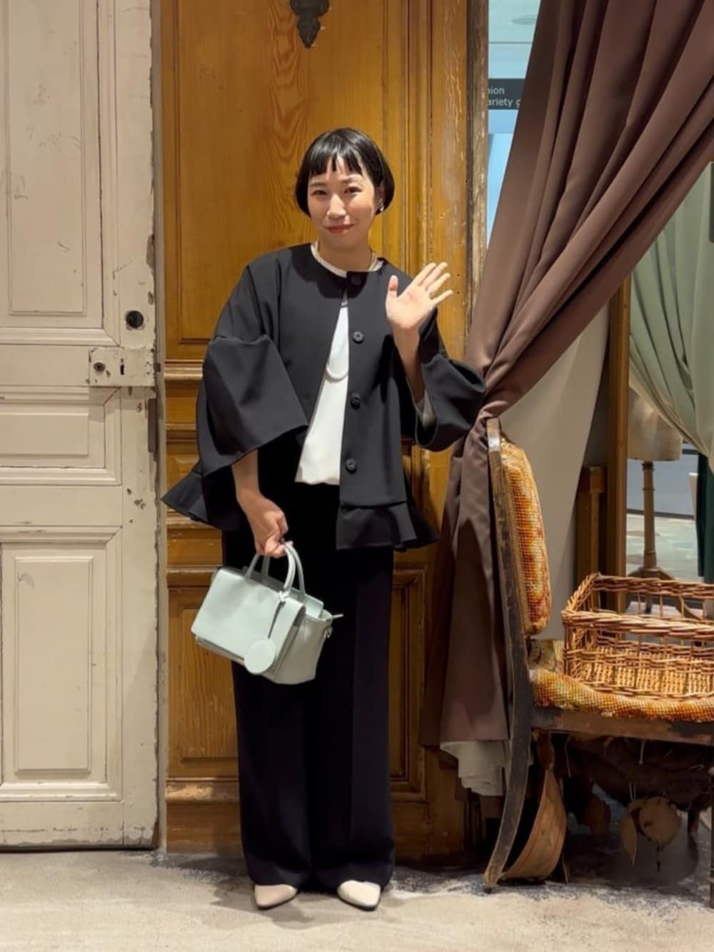 グリーン系のハンドバッグ、ブラック系のその他アウター、ブラック系のその他パンツを着用したレディースの冬コーディネートの3枚目の写真