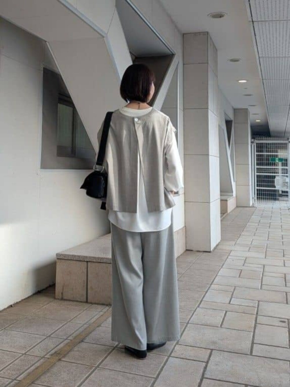 グレー系のシャツ/ブラウス、ホワイト系のシャツ/ブラウス、ブラック系のショルダーバッグを着用したレディースの春コーディネートの2枚目の写真