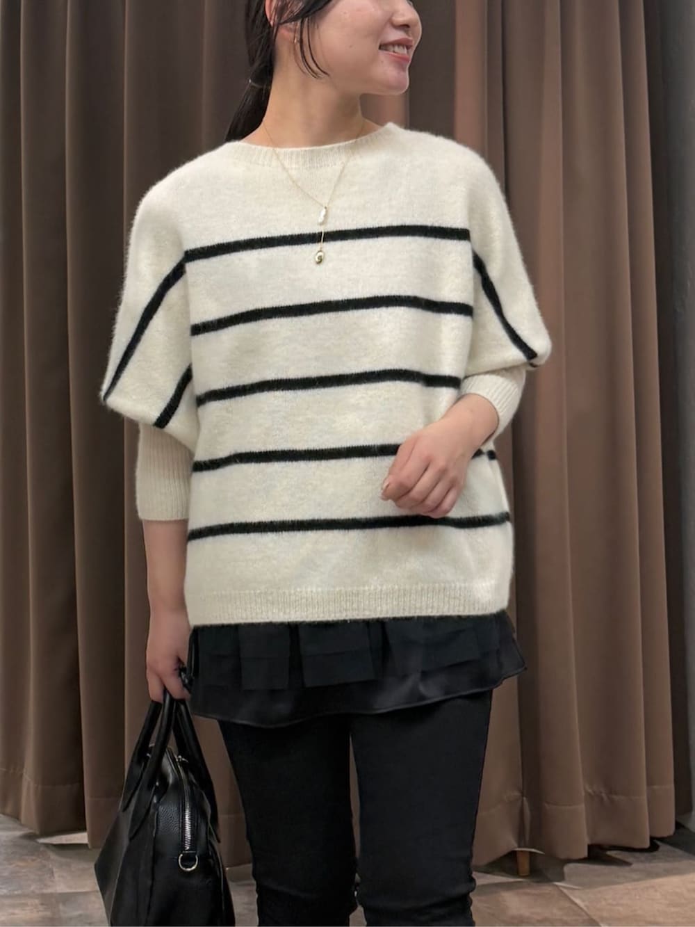 ブラック系のその他パンツ、ホワイト系のニット/セーター、ブラック系のタンクトップを着用したレディースの冬コーディネートの4枚目の写真