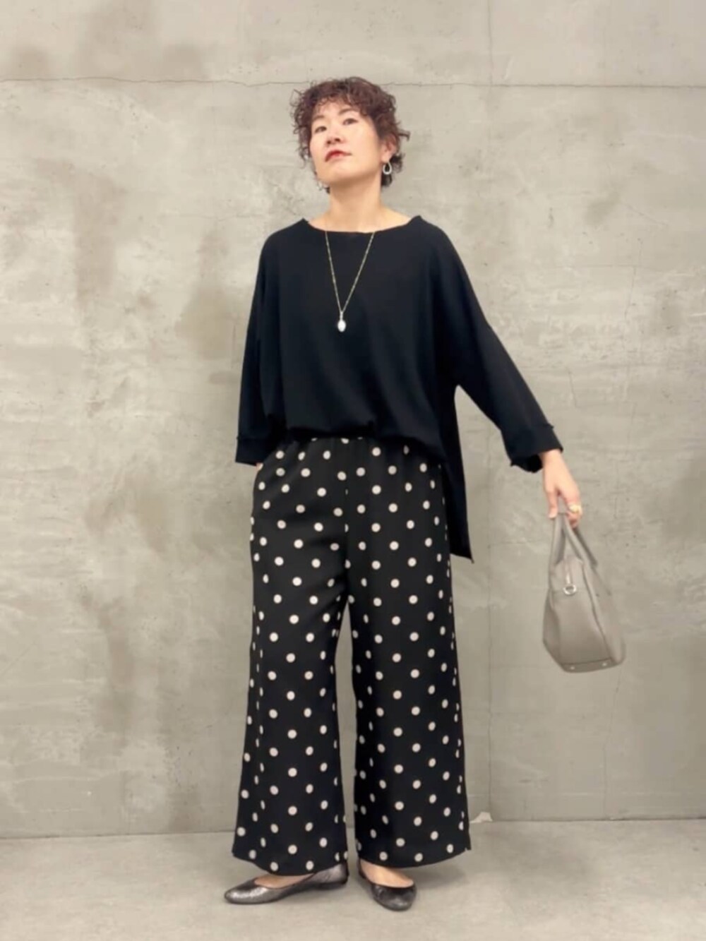 グレー系のボストンバッグ、ブラック系のTシャツ/カットソー、ブラック系のその他パンツを着用したレディースの春コーディネートの5枚目の写真