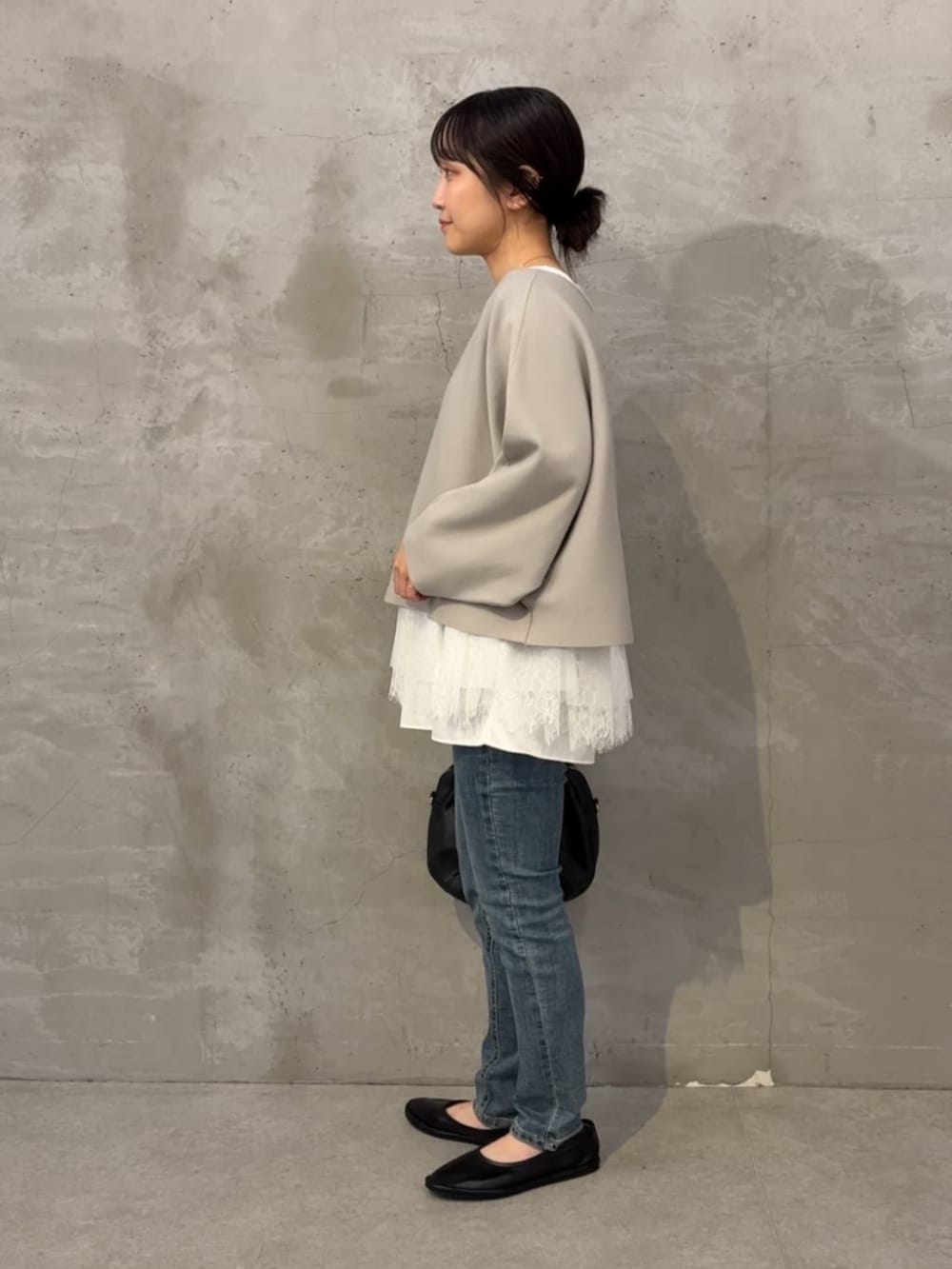 ブルー系のデニムパンツ、グレー系のニット/セーター、ホワイト系のタンクトップを着用したレディースの夏コーディネートの3枚目の写真