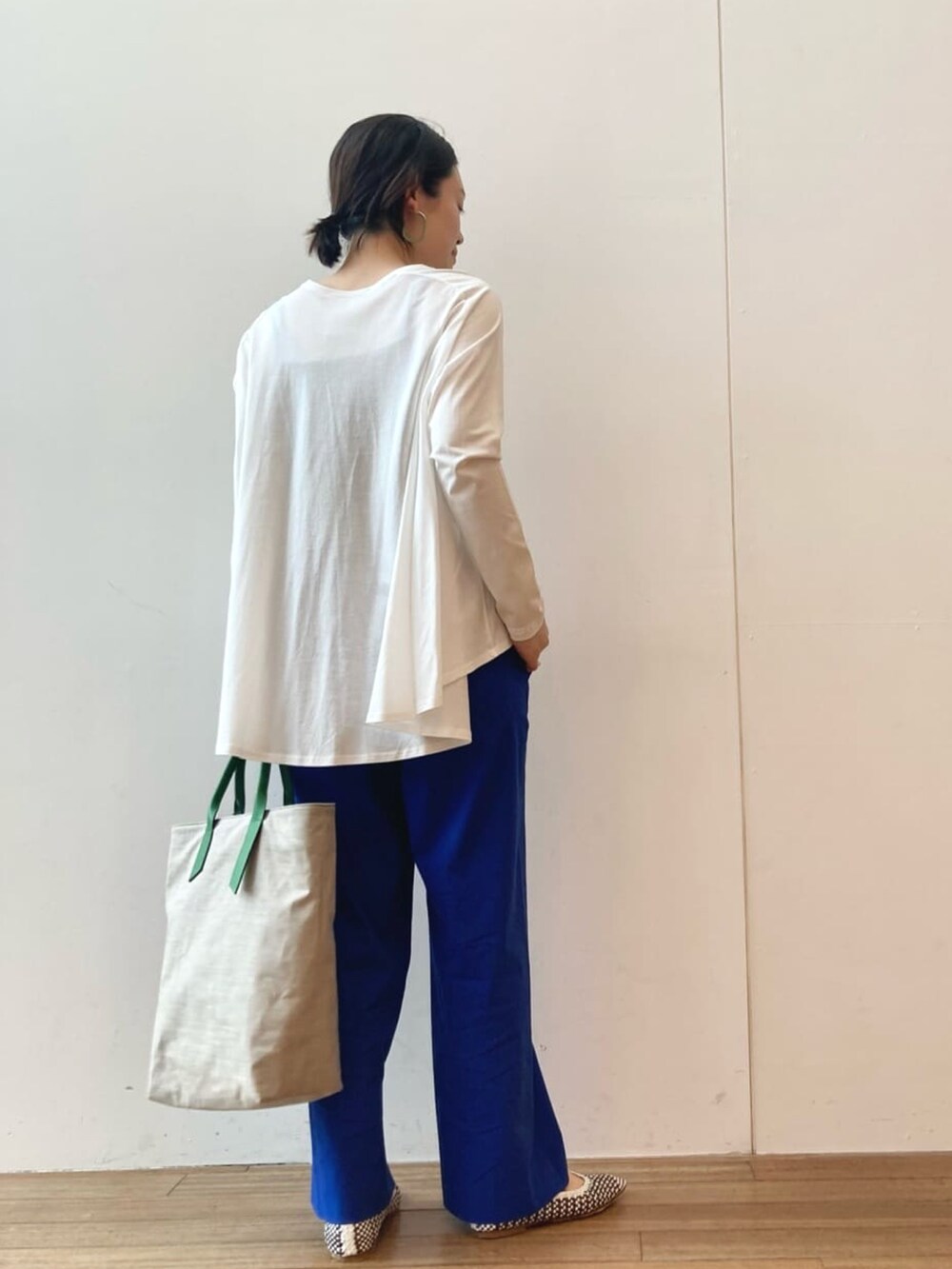 ホワイト系のTシャツ/カットソー、ブルー系のその他パンツ、グリーン系のトートバッグを着用したレディースの春コーディネートの3枚目の写真