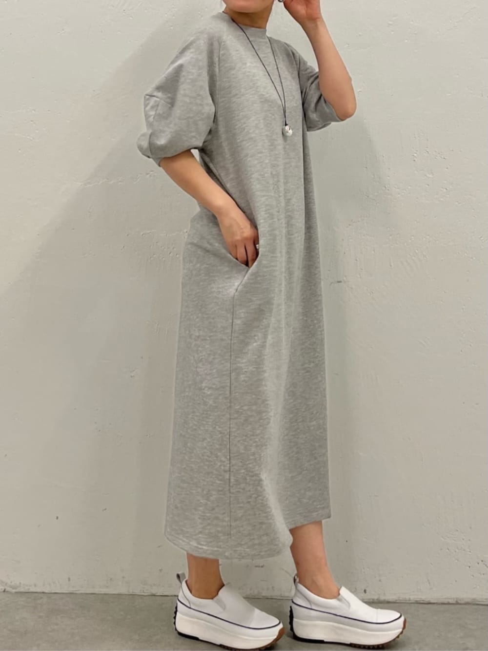 ブラック系のショルダーバッグ、グレー系のワンピース、シルバー系のリングを着用したレディースの冬コーディネートの6枚目の写真