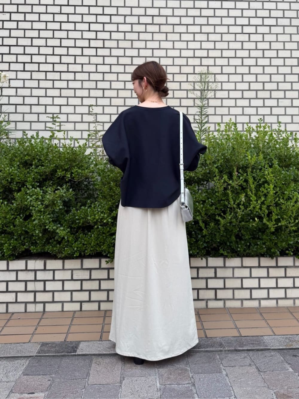 ベージュ系のスカート、ブルー系のカーディガン/ボレロ、シルバー系のトートバッグを着用したレディースの夏コーディネートの3枚目の写真
