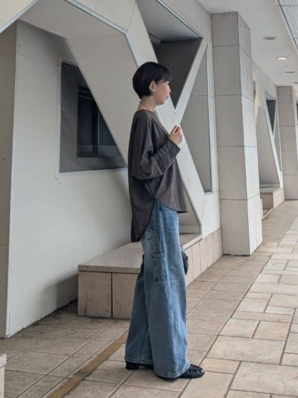ブラック系のボストンバッグ、ブルー系のその他パンツ、ブラウン系のTシャツ/カットソーを着用したレディースの夏コーディネートの2枚目の写真