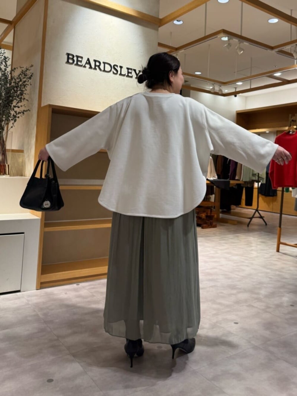 グリーン系のその他パンツ、ブラック系のブーツ、ブラック系のトートバッグを着用したレディースの冬コーディネートの5枚目の写真