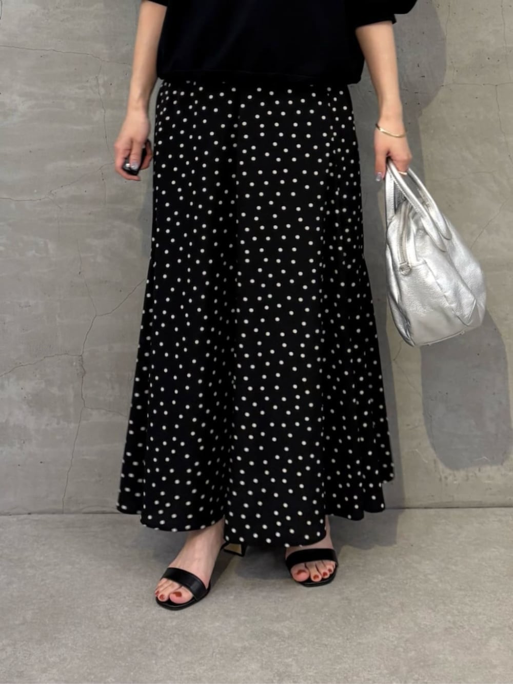 シルバー系のボストンバッグ、ブラック系のスカート、ブラック系のTシャツ/カットソーを着用したレディースの冬コーディネートの5枚目の写真