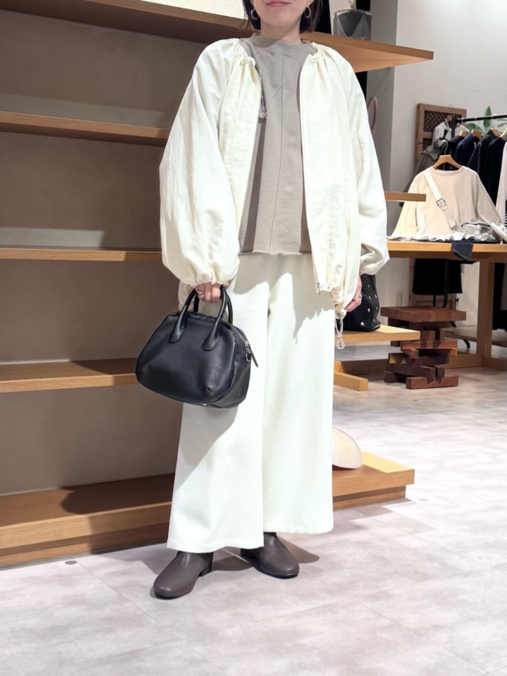 ブラック系のボストンバッグ、ブラウン系のTシャツ/カットソー、ホワイト系のその他パンツを着用したレディースの冬コーディネートの3枚目の写真