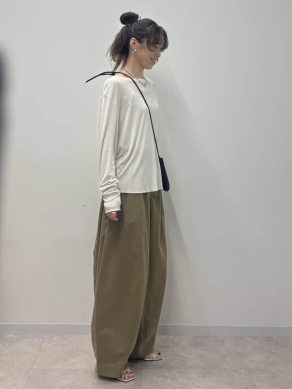 ブラック系のショルダーバッグ、イエロー系のその他パンツ、ホワイト系のTシャツ/カットソーを着用したレディースの春コーディネートの4枚目の写真