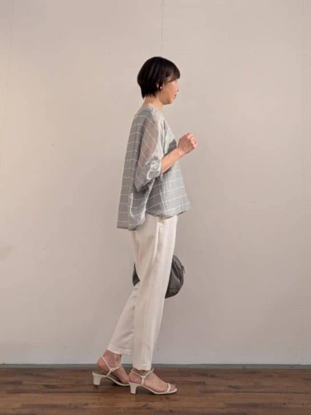 グレー系のボストンバッグ、グレー系のシャツ/ブラウス、ホワイト系のその他パンツを着用したレディースの春コーディネートの2枚目の写真