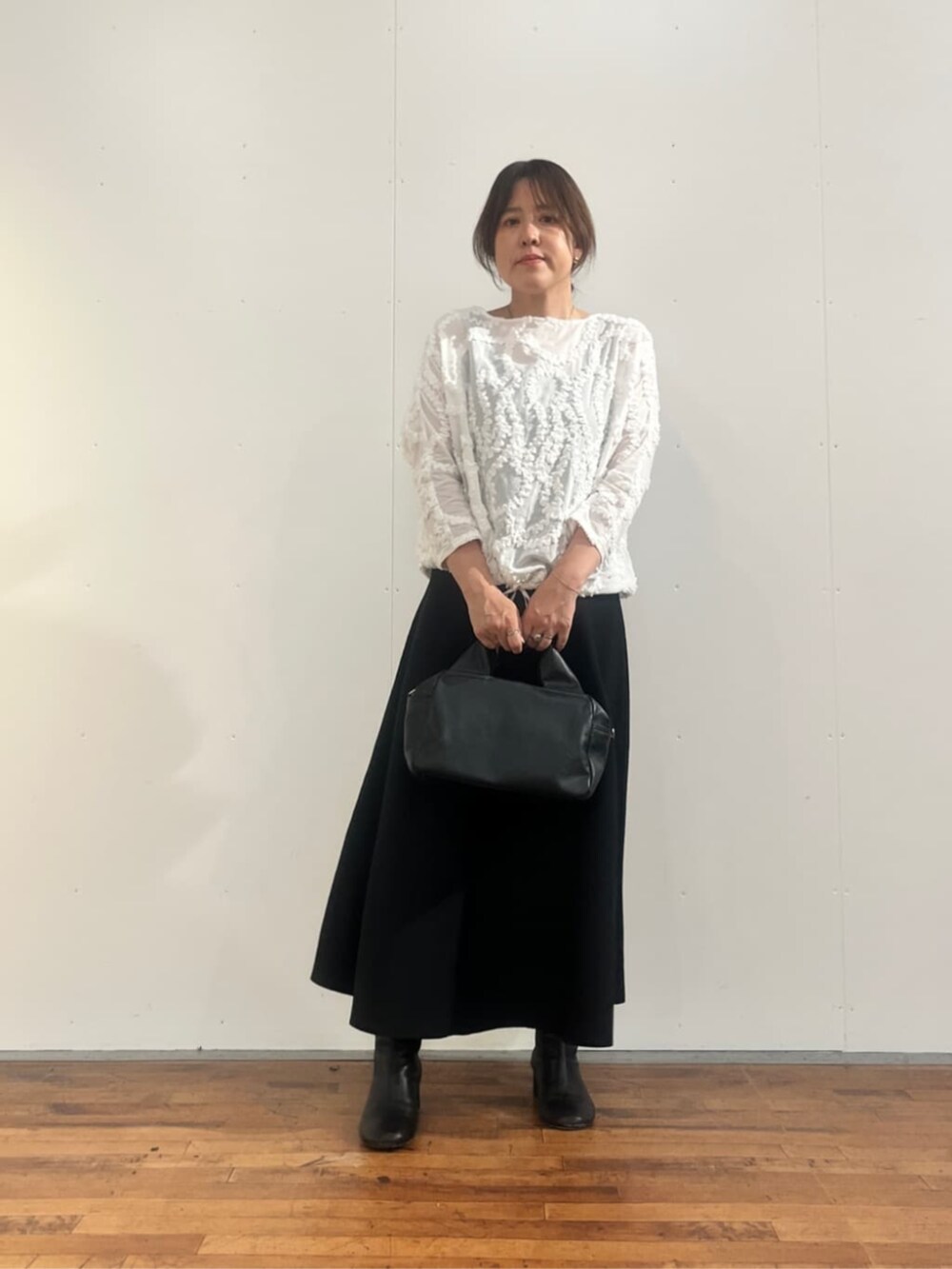 ブラック系のボストンバッグ、ブラック系のスカート、ホワイト系のシャツ/ブラウスを着用したレディースの夏コーディネートの5枚目の写真