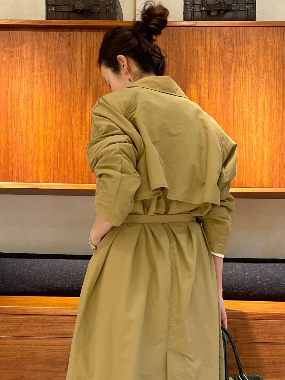 ベージュ系のその他アウター、ブラック系のニット/セーター、グリーン系のトートバッグを着用したレディースの春コーディネートの2枚目の写真