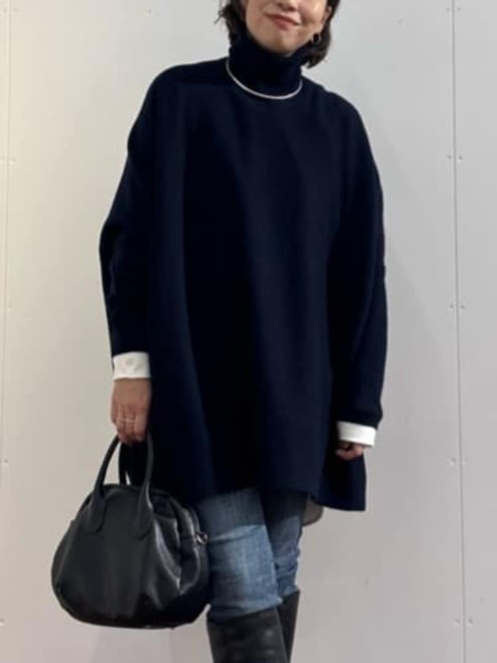 ブルー系のデニムパンツ、ブラック系のトートバッグ、ブルー系のニット/セーターを着用したレディースの秋コーディネートの4枚目の写真