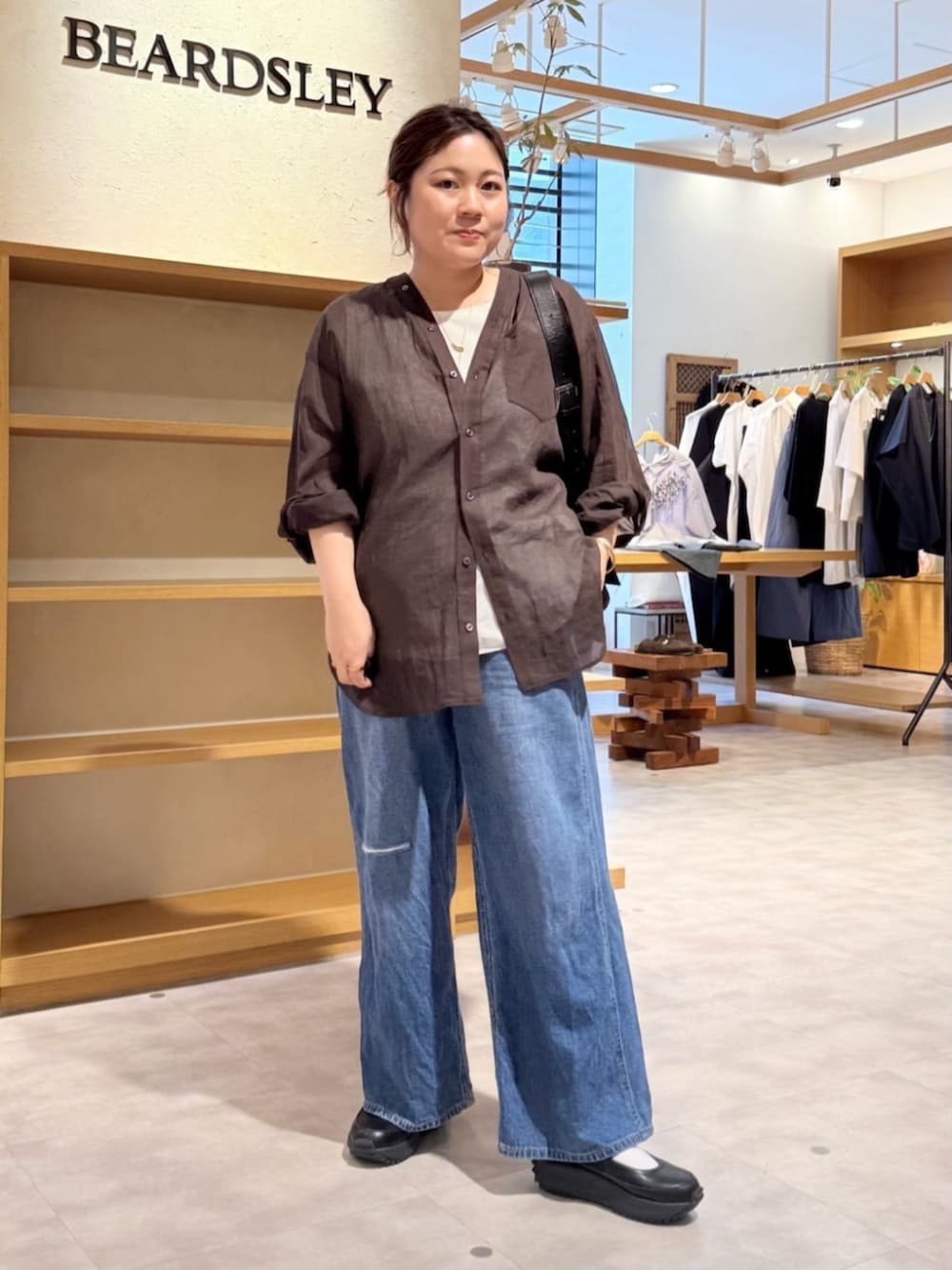 ブルー系のその他パンツ、ブラック系のスニーカー、ブラウン系のシャツ/ブラウスを着用したレディースの春コーディネートの2枚目の写真