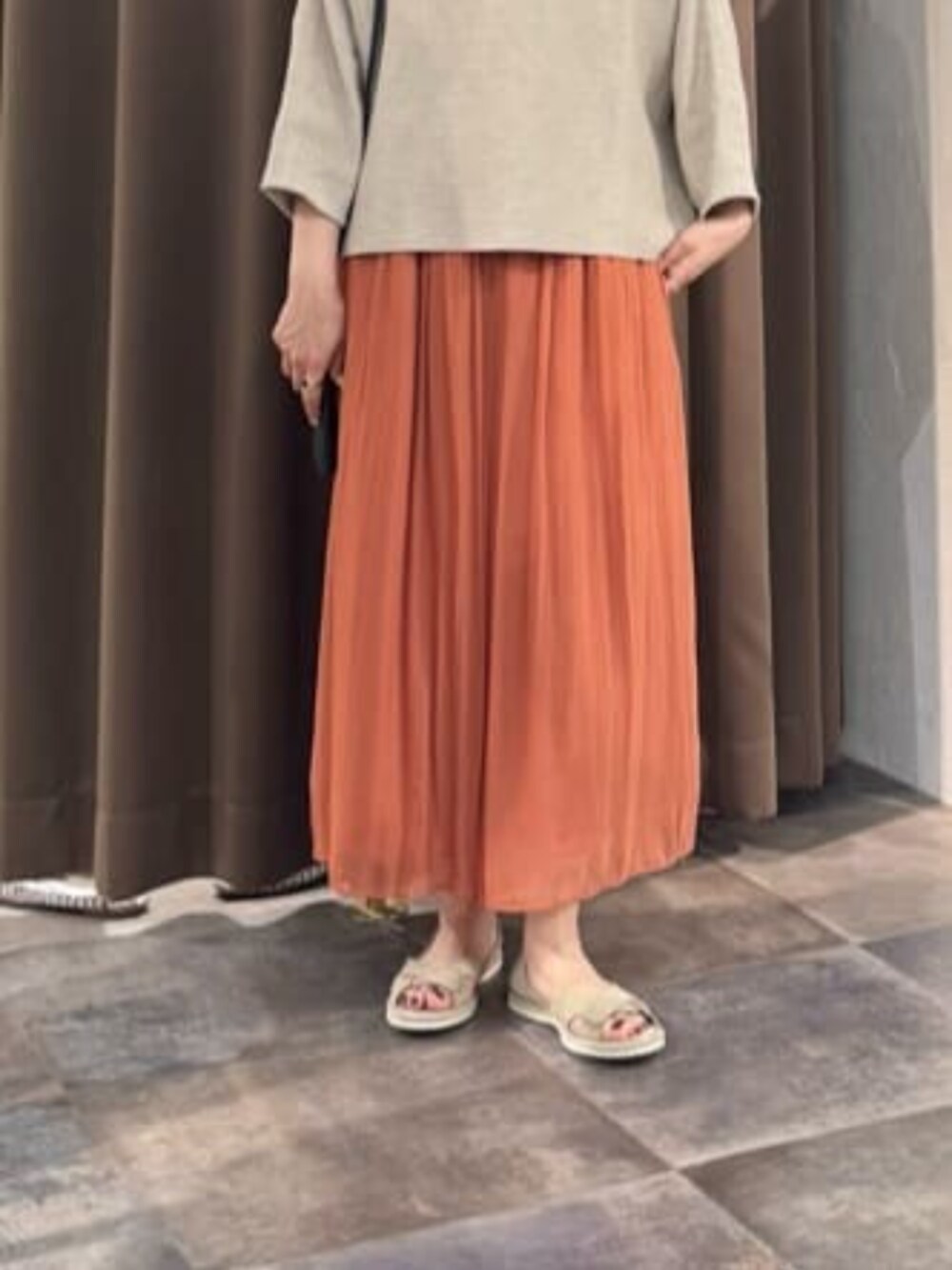 オレンジ系のその他パンツ、ベージュ系のニット/セーターを着用したレディースの春コーディネートの8枚目の写真