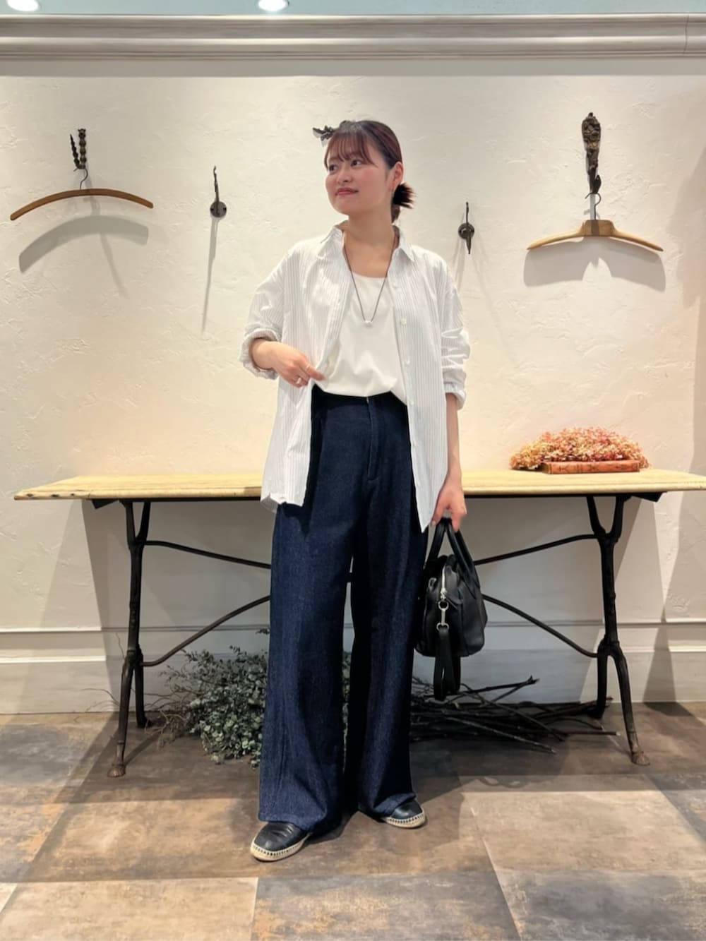 ブラック系のボストンバッグ、ブルー系のその他パンツ、ホワイト系のシャツ/ブラウスを着用したレディースの冬コーディネートの2枚目の写真