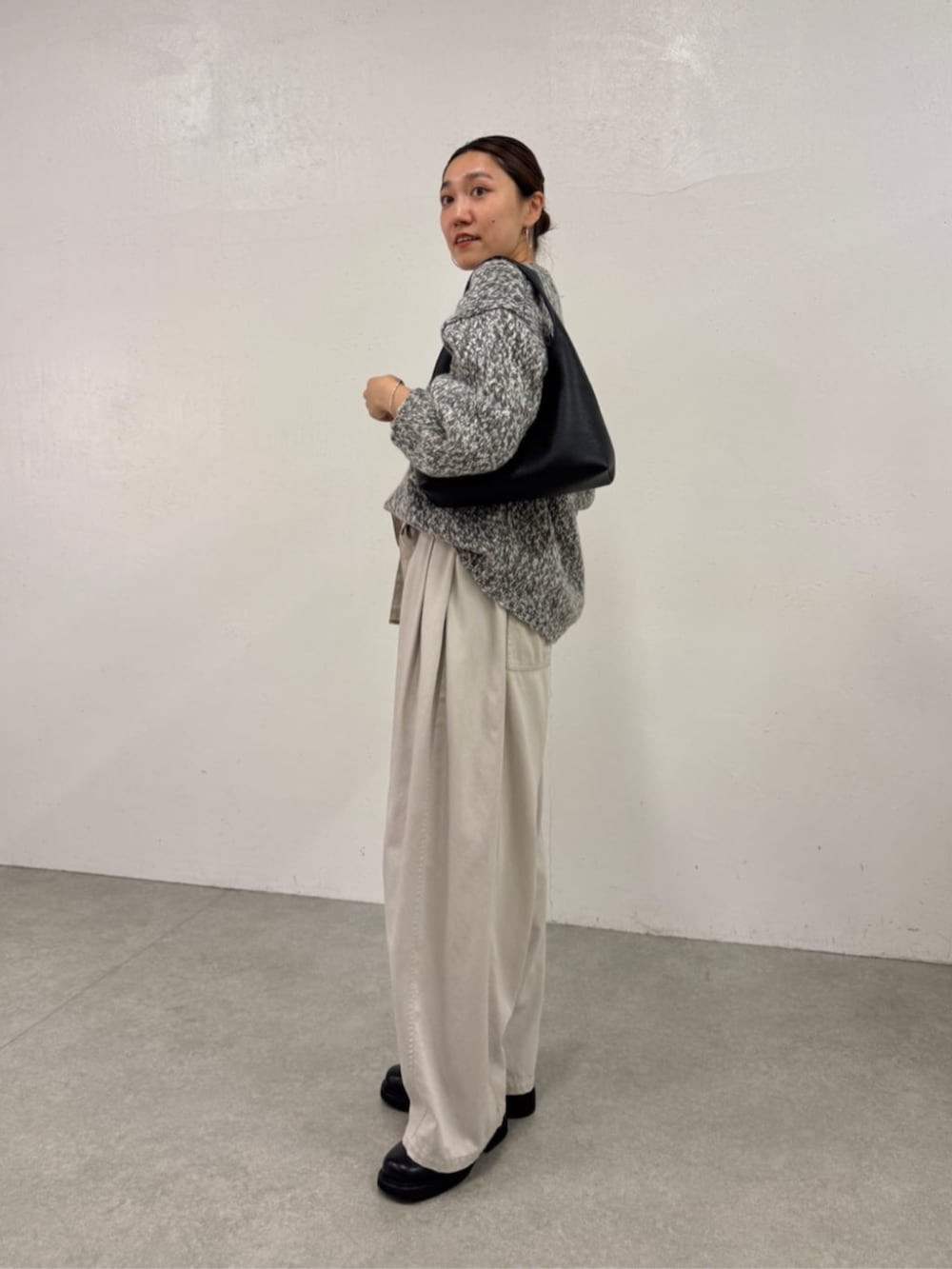 ブラック系のローファー、ホワイト系のその他パンツ、グレー系のニット/セーターを着用したレディースの秋コーディネートの2枚目の写真