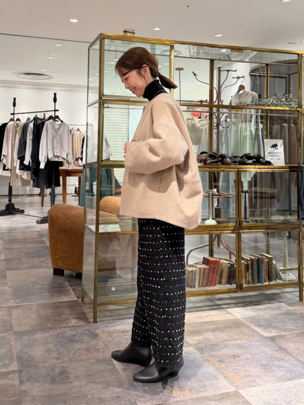 ブラック系のその他パンツ、ベージュ系のノーカラーコートを着用したレディースの冬コーディネートの2枚目の写真