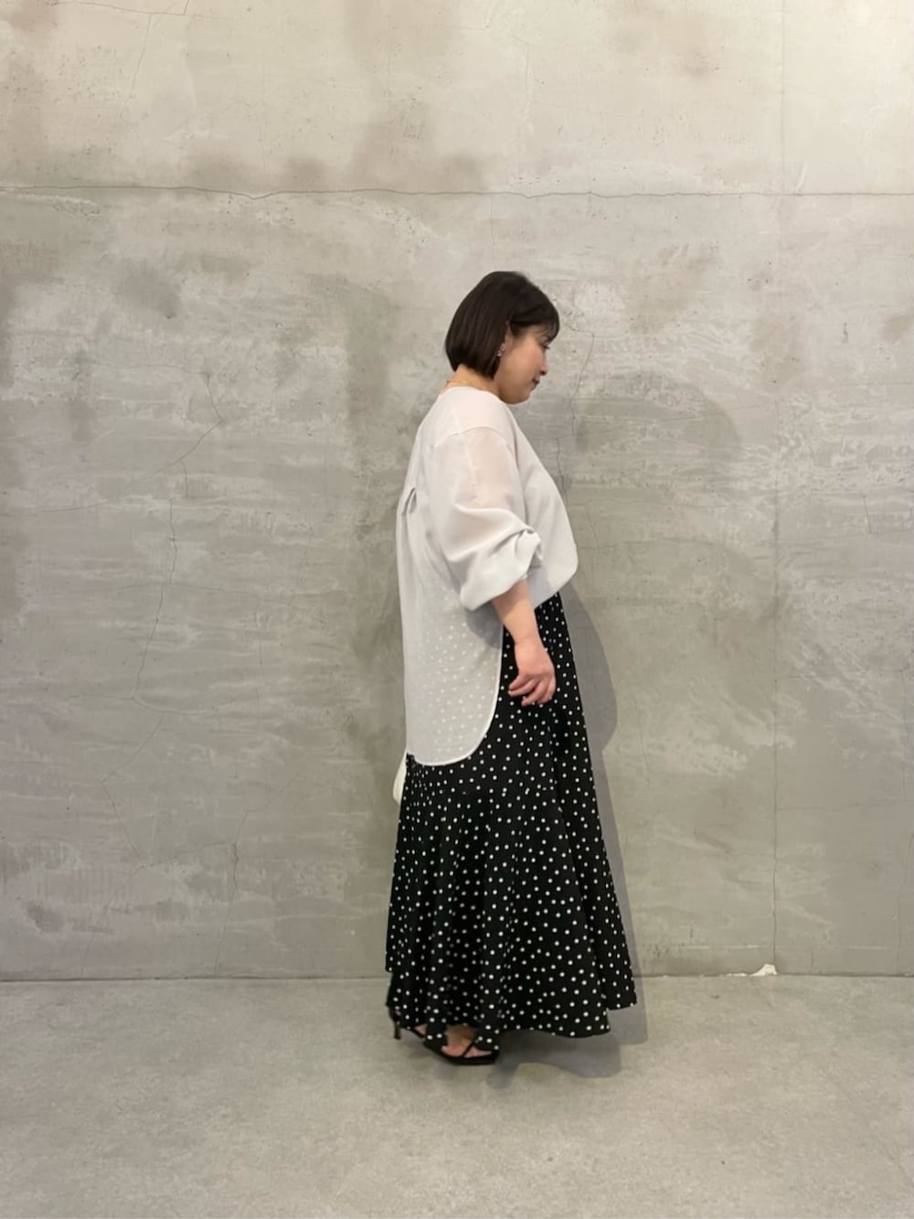 ブラック系のスカート、ホワイト系のトートバッグ、グレー系のシャツ/ブラウスを着用したレディースの冬コーディネートの7枚目の写真