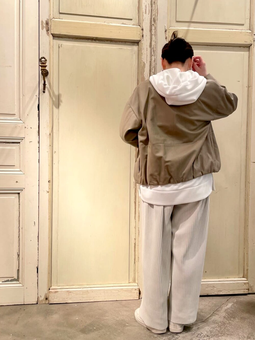 ベージュ系のブルゾン、ホワイト系のパーカー、ホワイト系のその他パンツを着用したレディースの春コーディネートの3枚目の写真