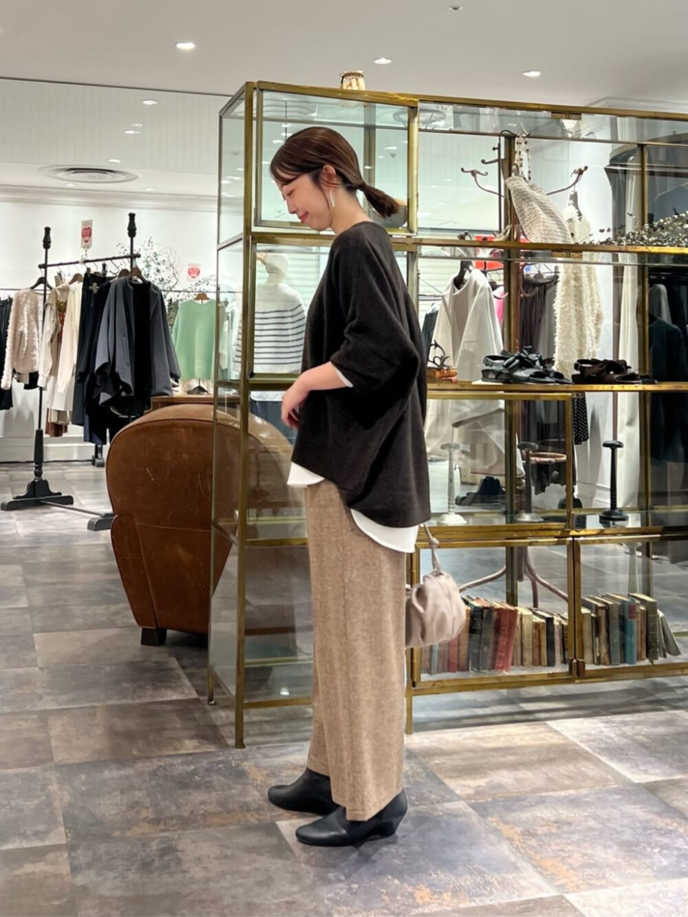 ベージュ系のショルダーバッグ、ブラウン系のその他パンツ、ホワイト系のシャツ/ブラウスを着用したレディースの秋コーディネートの2枚目の写真