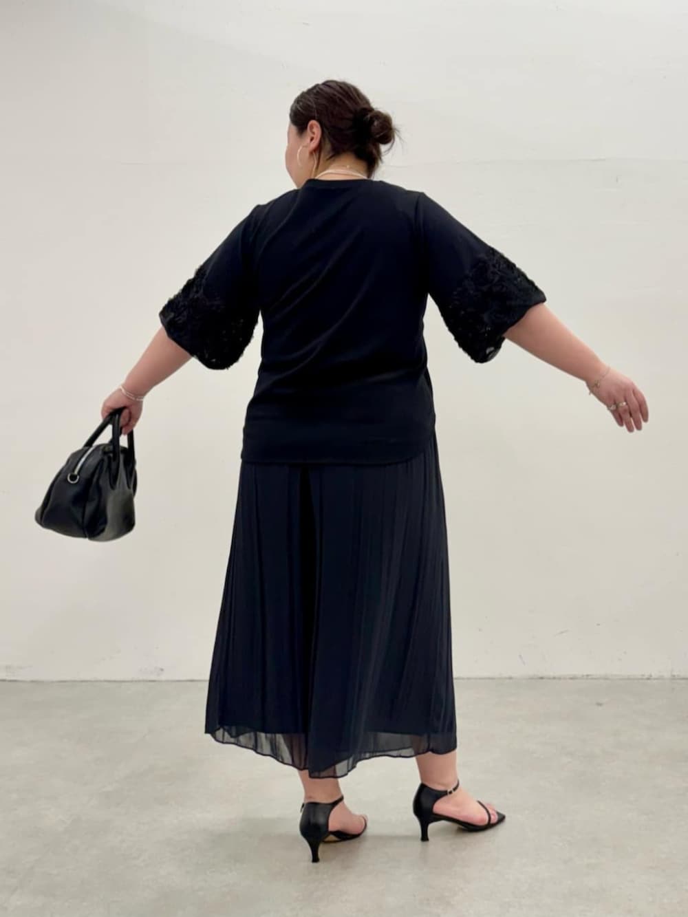 ブラック系のその他パンツ、ブラック系のTシャツ/カットソーを着用したレディースの春コーディネートの5枚目の写真