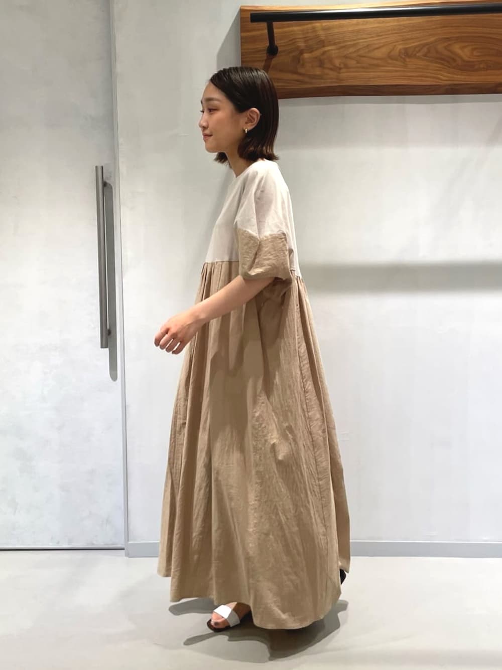 ベージュ系のワンピースを着用したレディースの夏コーディネートの2枚目の写真