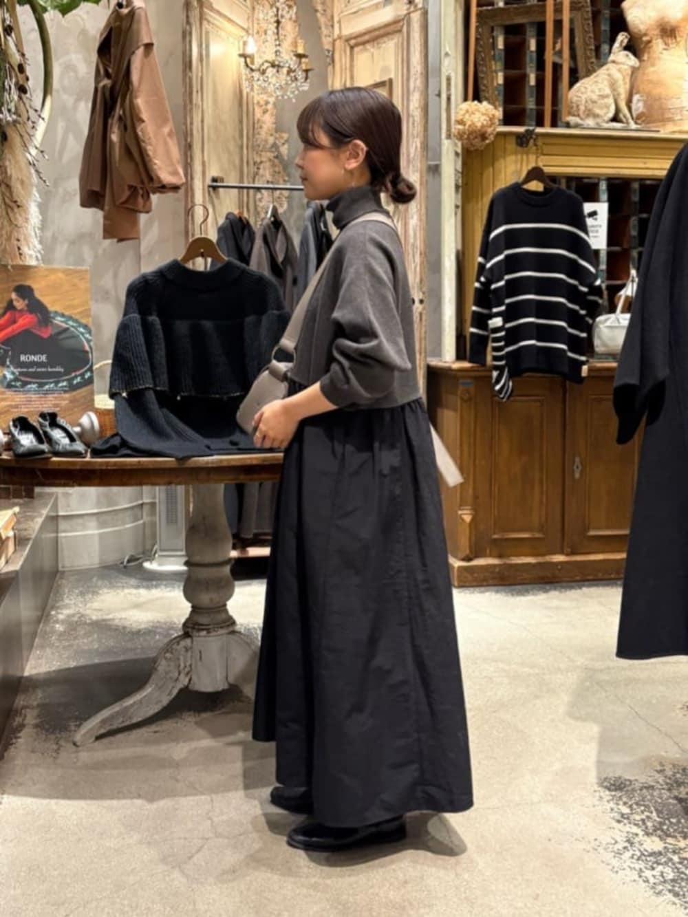 グレー系のワンピース、グレー系のショルダーバッグを着用したレディースの冬コーディネートの3枚目の写真