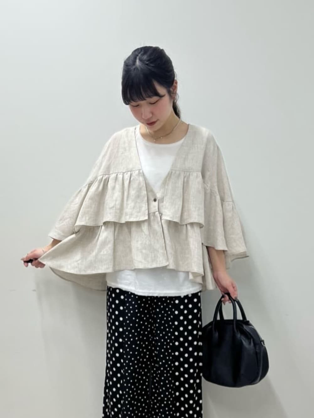 ブラック系のボストンバッグ、ホワイト系のシャツ/ブラウス、ブラック系のその他パンツを着用したレディースの春コーディネートの7枚目の写真