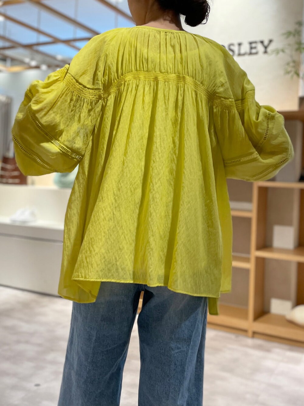 イエロー系のシャツ/ブラウス、ホワイト系のタンクトップ、ベージュ系のかごバッグを着用したレディースの春コーディネートの3枚目の写真