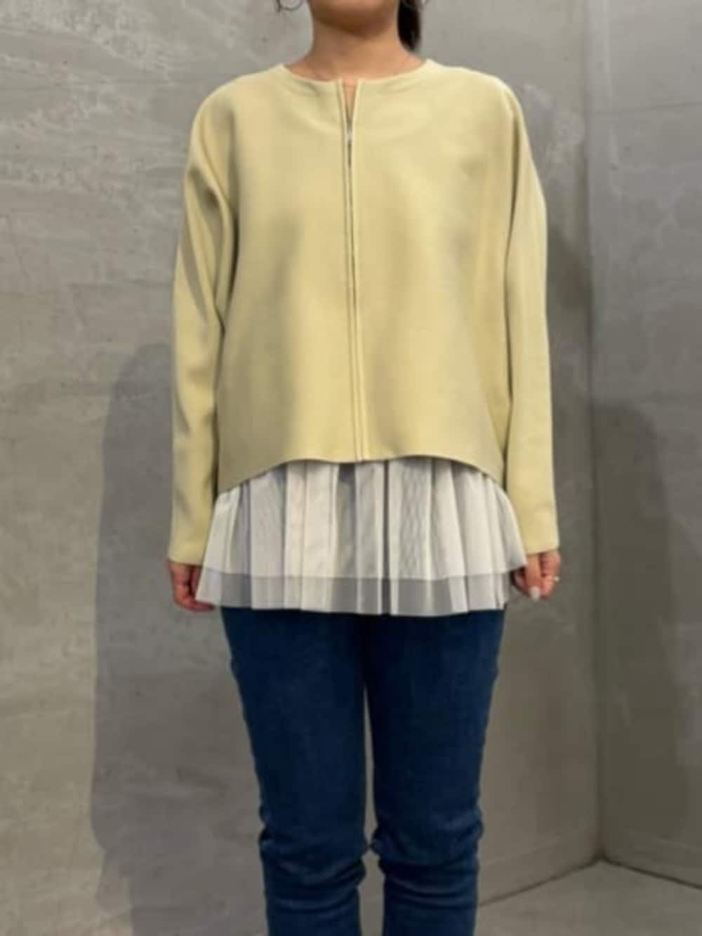 ホワイト系のキャミソール、ブルー系のデニムパンツ、ベージュ系のカーディガン/ボレロを着用したレディースの秋コーディネートの3枚目の写真