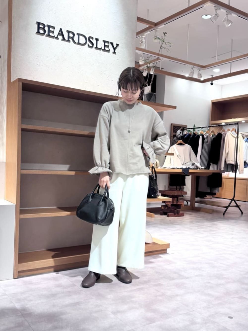 ブラック系のボストンバッグ、ブラウン系のTシャツ/カットソー、ホワイト系のその他パンツを着用したレディースの冬コーディネートの6枚目の写真