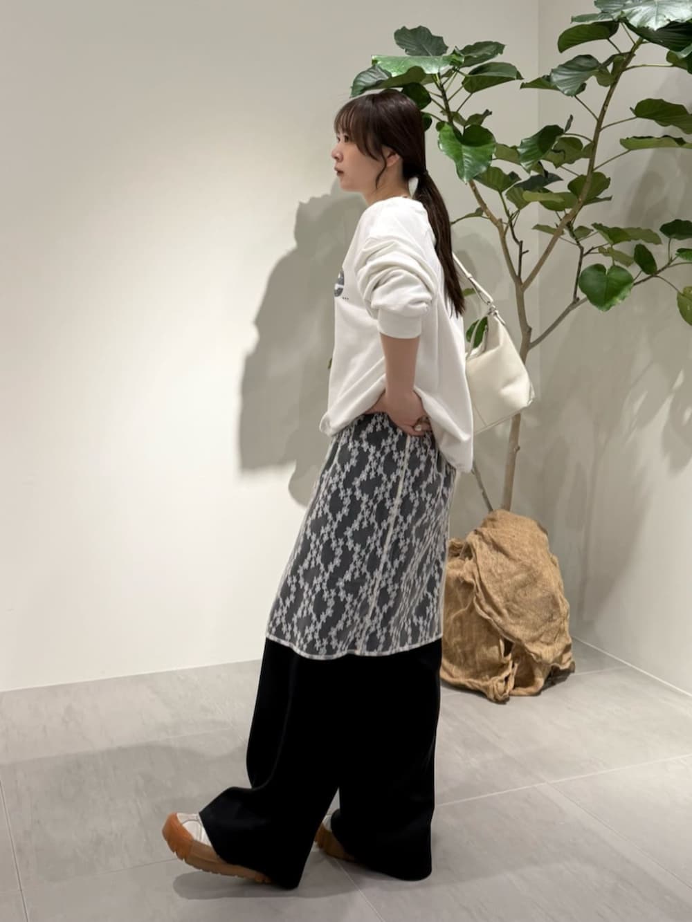 ブラック系のその他パンツ、グレー系のニット/セーター、ホワイト系のTシャツ/カットソーを着用したレディースの春コーディネートの3枚目の写真