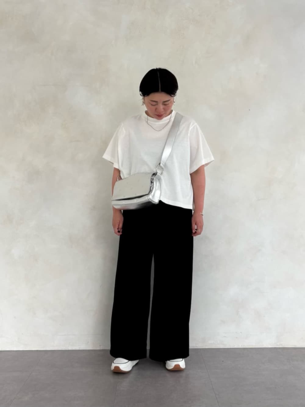 シルバー系のショルダーバッグ、ホワイト系のTシャツ/カットソー、ホワイト系のスニーカーを着用したレディースの春コーディネートの2枚目の写真
