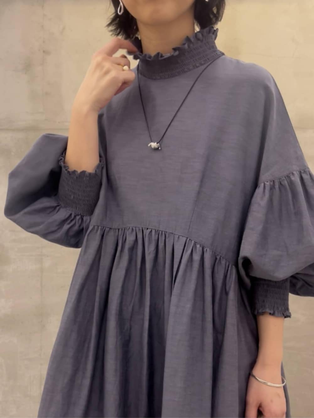 グレー系のボストンバッグ、グレー系のワンピースを着用したレディースの冬コーディネートの8枚目の写真