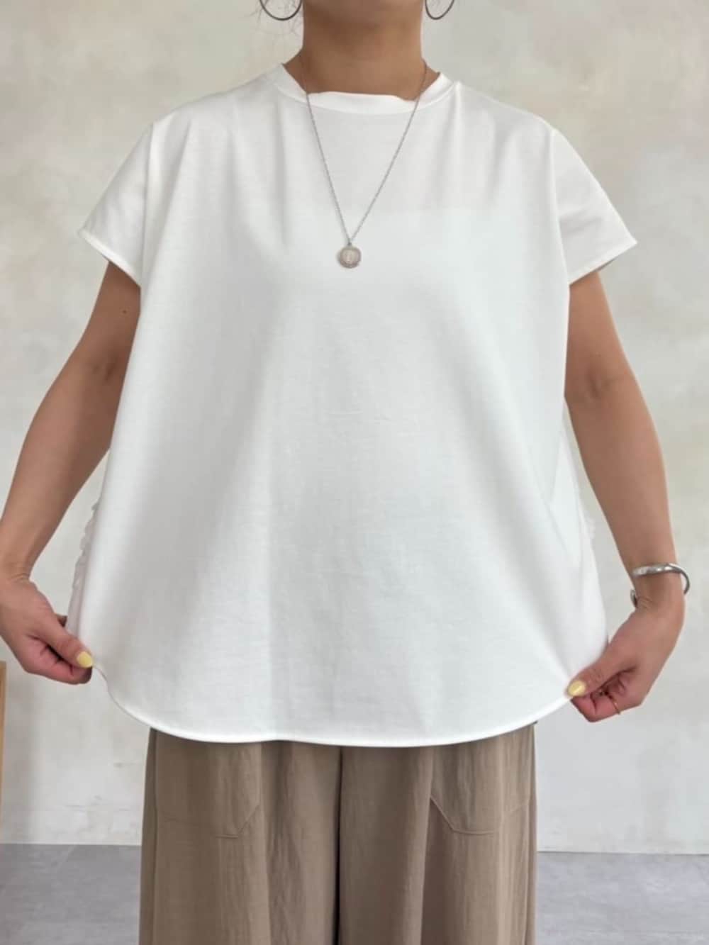 ベージュ系のその他パンツ、ホワイト系のサンダル、ホワイト系のTシャツ/カットソーを着用したレディースの春コーディネートの5枚目の写真