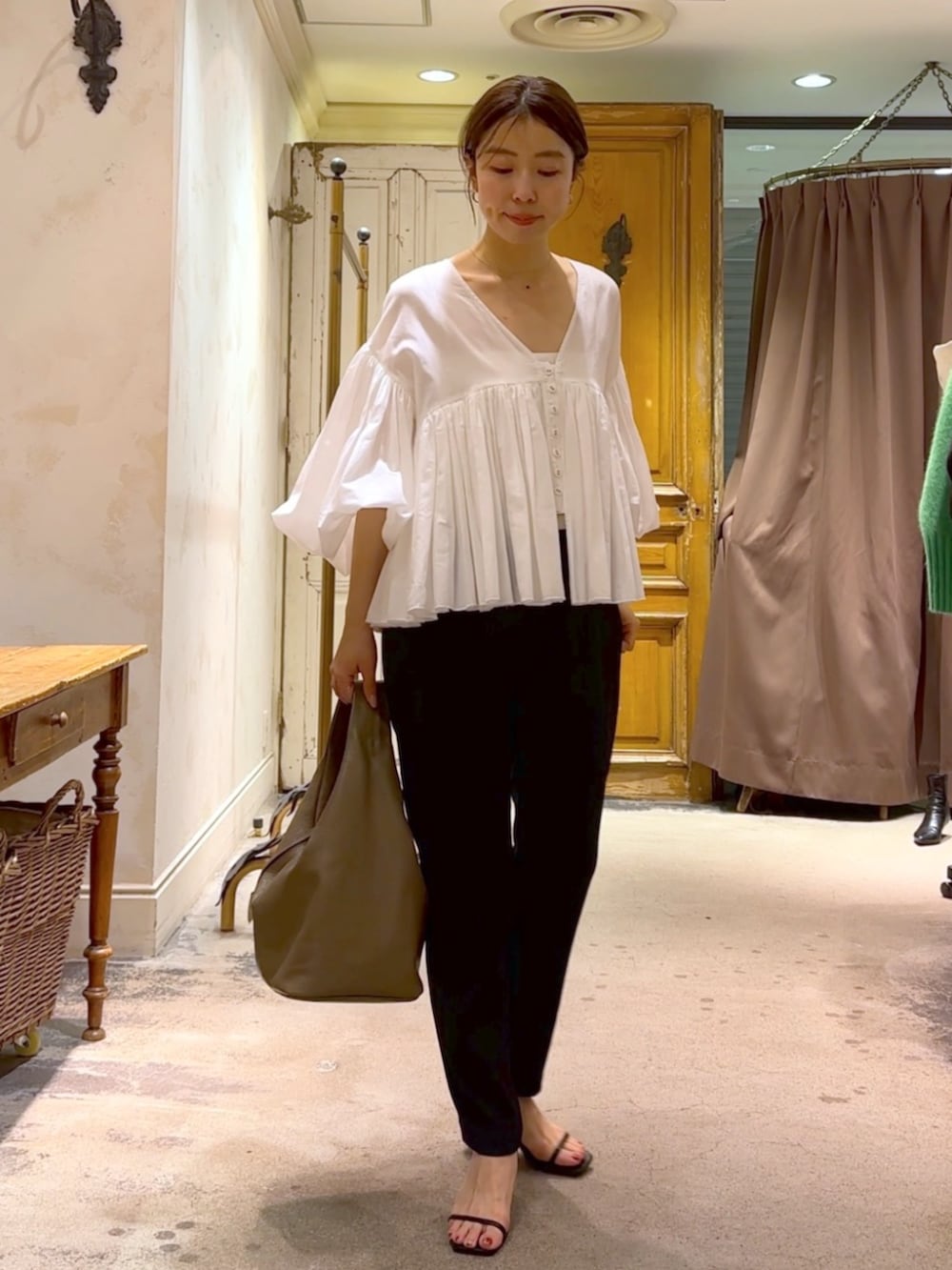 ブラウン系のトートバッグ、ブラック系のその他パンツ、ホワイト系のシャツ/ブラウスを着用したレディースの冬コーディネートの3枚目の写真